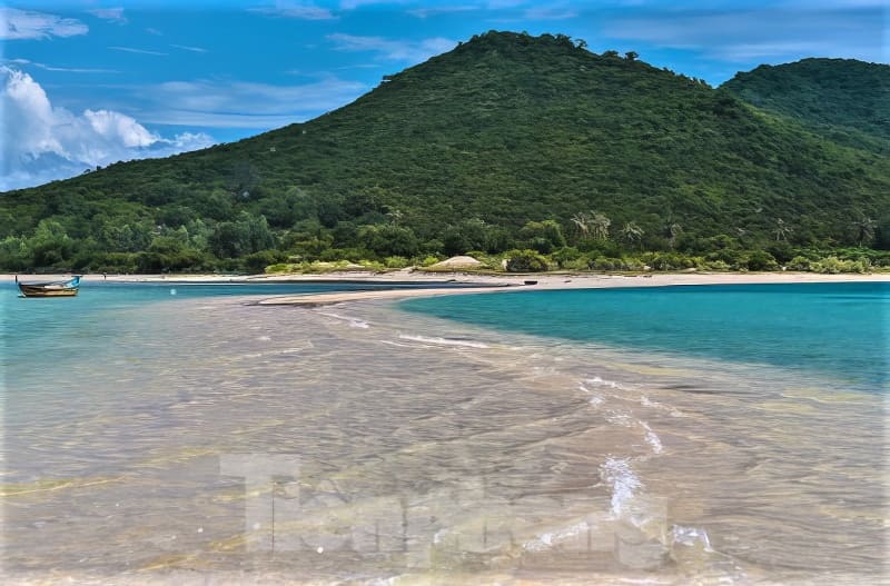 Kỳ thú những cung đường bộ xuyên biển - Ảnh 10. Một khung cảnh bãi biển thanh bình với con đường cát trắng dẫn đến ngọn đồi xanh mướt. Nước biển màu ngọc lam và một chiếc thuyền nhỏ càng làm tăng thêm bầu không khí yên tĩnh.